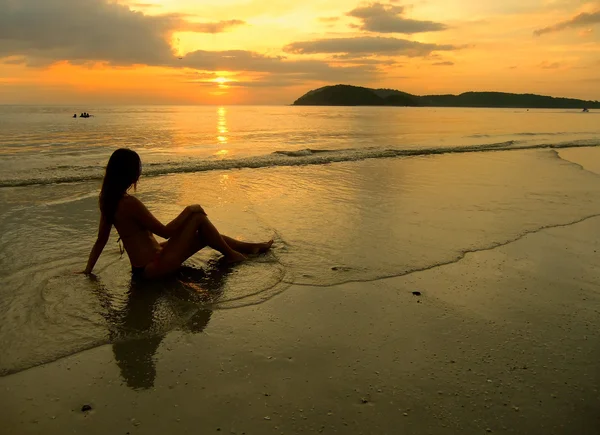 Mujer joven en bikini sentada en una playa al atardecer, Langkawi isl —  Fotos de Stock