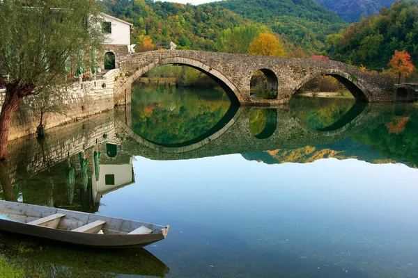 Gebogen brug weerspiegeld in de crnojevica rivier, montenegro — Stockfoto