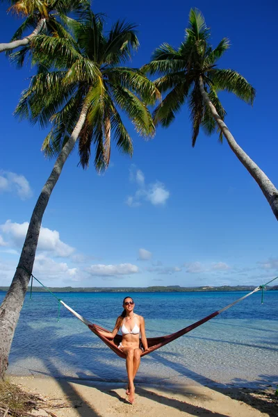 Mujer joven en bikini sentada en una hamaca entre palmeras, O —  Fotos de Stock