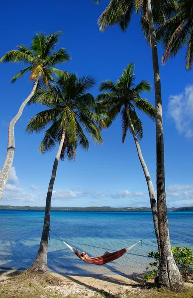Ung kvinna i bikini att lägga i en hängmatta mellan palmerna, — Stockfoto