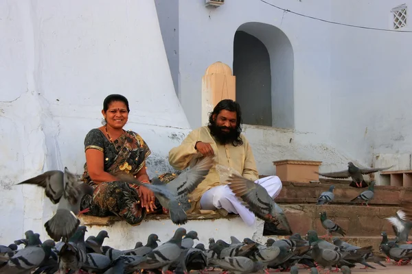 Indian man and woman feeding pigeons near holy lake, Pushkar, In — Stock Photo, Image