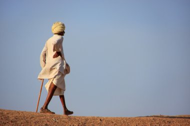 Local man walking on a hill, Khichan village, India clipart