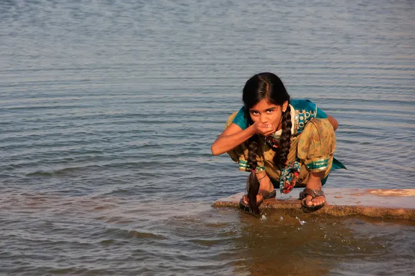 Místní dívka pití z vodní nádrže, vesnice khichan, Indie — Stock fotografie