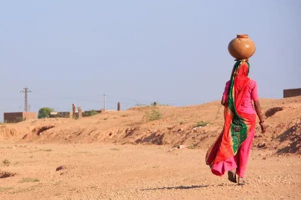 Femme locale portant un bocal avec de l'eau sur la tête, village Khichan — Photo