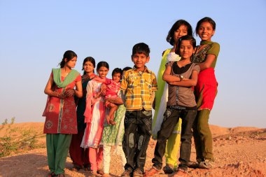 Group of local kids playing near water reservoir, Khichan villag clipart