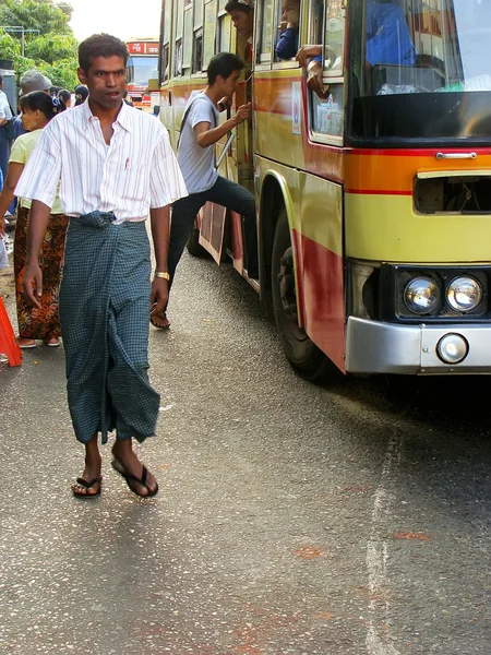 ヤンゴンのにぎやかな通りの上を歩いての伝統的な衣装の男, — ストック写真