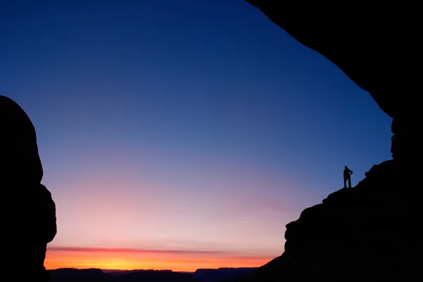 Person silhouetted at North Window Arch at sunrise, Arches Natio — Stock Photo, Image