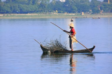 Yerel adam, bir teknenin yanında u bein Köprüsü, amarapura, myanmar