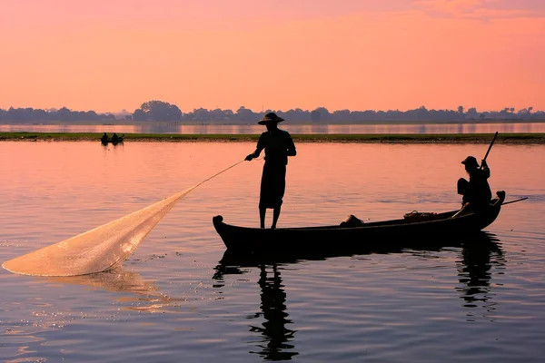 Местный житель ловит рыбу с помощью сети на закате, Фапура, Мьянма — стоковое фото
