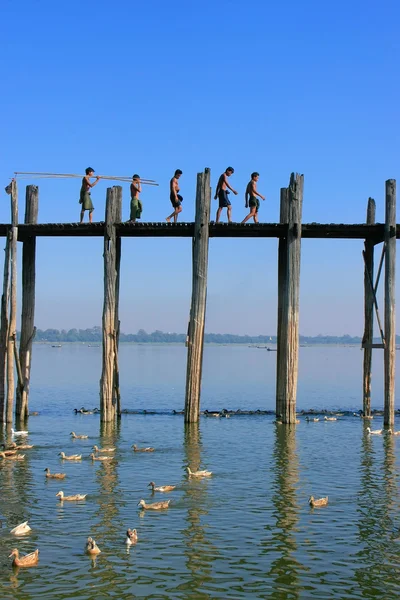 Local kids with fishing poles walking on U Bein bridge, Amarapur — Stock Photo, Image