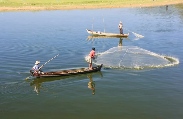 Lokale man vissen met een net van een boot, amarapura, myanmar — Stockfoto