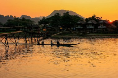 VANG VİANG, LAOS - 25 Kasım 2011 'de Vang Vieng, Laos' ta Nam Song Nehri üzerinde hareket eden sürat teknesi. Vang Vieng, kireçtaşı bir karst arazisinde turizm için popüler bir yerdir..