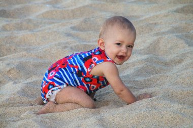 Yavru kız kumsalda sürünüyor