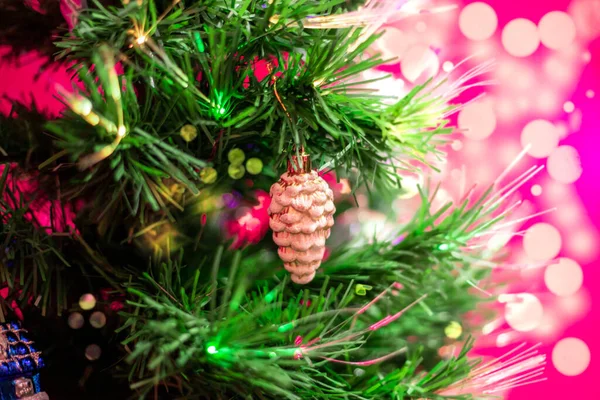 お祝いの木のクリスマスツリーのおもちゃ 光の光の中で輝く 背景がぼやけて — ストック写真