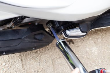 Metal bir şırınga kullanarak motorun motoruna motor yağı dökülüyor. Yağ değişimi ve motosiklet bakımı.