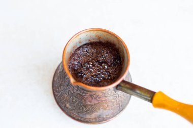 Açık arkaplanda kahverengi bir Türk köpüklü taze demlenmiş kahve. Günaydın canlandırıcı içecek..