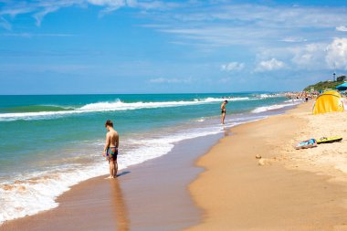 Dalgalar ve tatilcilerle güneşli kumlu sahil. Anapa, Rusya-07.07.2021
