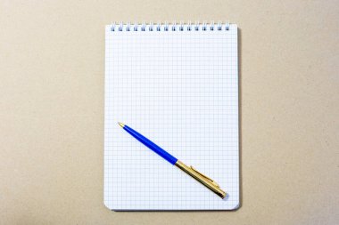 Üzerinde boş defter ve tükenmez kalem kağıdı var.