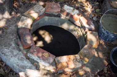 Septik kuyunun ağzına tuğla örüyorlar. Çimentoyla çalışmak, foseptik tankı inşa etmek..