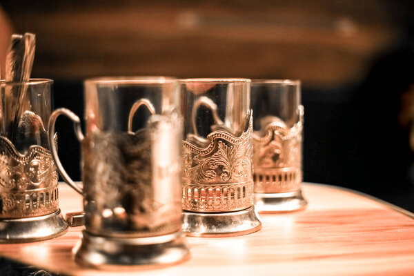 glasses in iron cup holders stand on a table in the evening at dusk