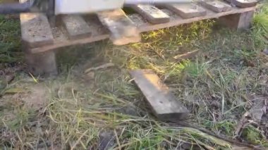 Bir adam bahçede elektrikli testereyle odun kesiyor. Özel bir evin ısıtılması