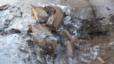Bir adam büyük bir baltayla odun keser. Kışın konutların ısıtılması için yakıt tedariği