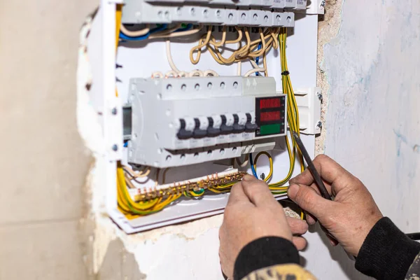Bir elektrikçi eve bir elektrik paneli kuruyor. Elektrik iletimi, aktifleştirme ve koruma.