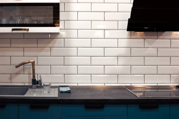 Design de cuisine avec carreaux de briques blanches et comptoirs sombres. Accueil intérieur moderne — Photo