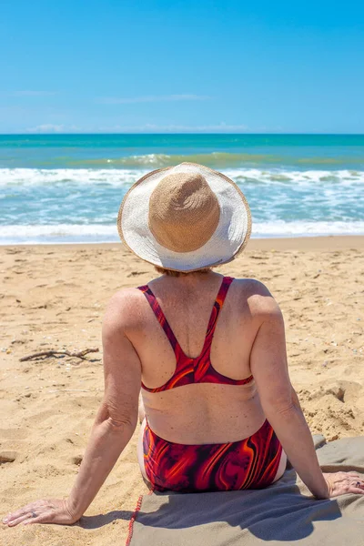 Dojrzała Kobieta Stroju Kąpielowym Siedzi Piaszczystym Brzegu Patrzy Morze Widok — Zdjęcie stockowe