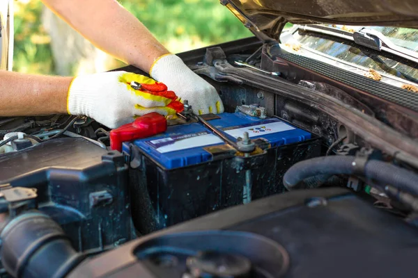 Ein Mann Schraubt Eine Autobatteriehalterung Reparatur Und Austausch Der Batterie lizenzfreie Stockfotos