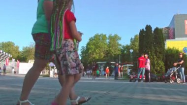 Turistler güneşli bir yaz gününde şehrin sokaklarında yürürler. Seyahat ve turizm.