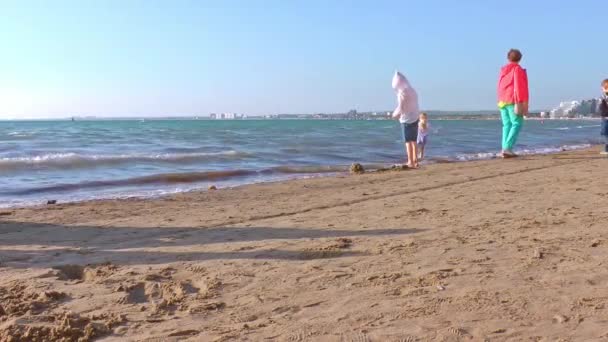 Toeristen wandelen langs de kust op een zomerse zonnige dag. Reizen en toerisme. — Stockvideo