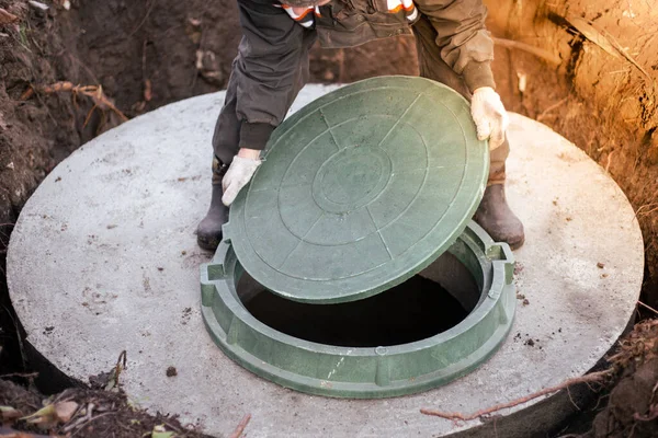 Der Installateur Deckt Den Kanalschacht Mit Einem Kanaldeckel Wasserversorgung Und — Stockfoto