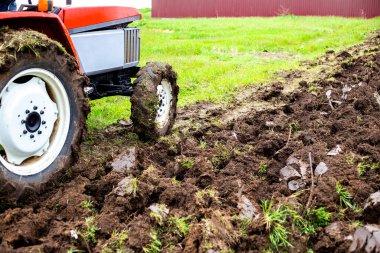 Traktör baharın başlarında bir sabanla bahçedeki araziyi sürer. Toprağı ekin ekmeye hazırlıyorum.