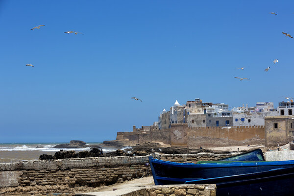 Лодки на берегу океана в марокканском городе
