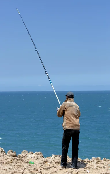 Homem pega um peixe no oceano — Fotografia de Stock