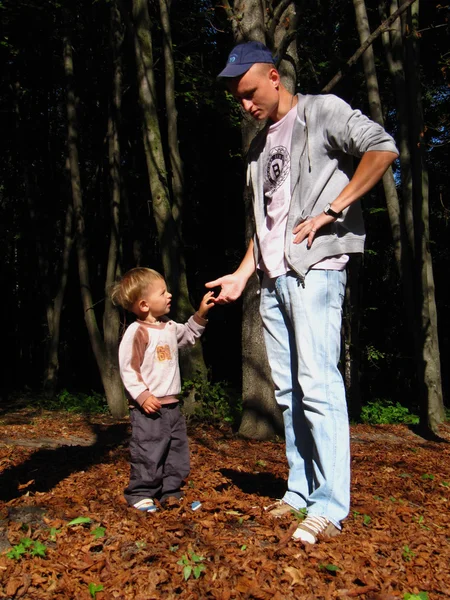 Far och son står och pratar i en park i höst — Stockfoto