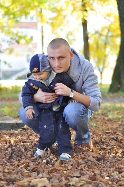 Otec a malý syn na procházce v podzimním parku — Stock fotografie
