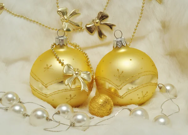 Decorazione di Natale - palle d'oro su pelo bianco, inchini, perle — Foto Stock