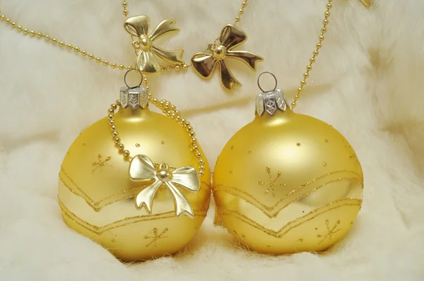 Décoration de Noël - deux boules d'or sur fourrure blanche et arcs — Photo