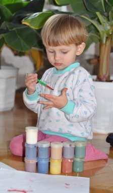 huzurlu çocuk fırçayla boyama çalışıyor