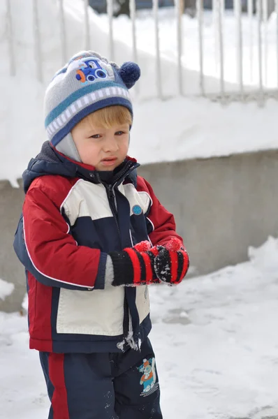Sad little boy on a snowy landscape with space for text — Stock Photo, Image