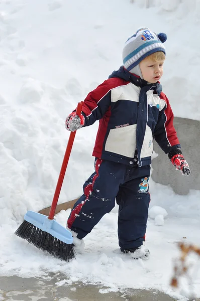A child with a brush running on snowy landscapes with space for — Stock Photo, Image