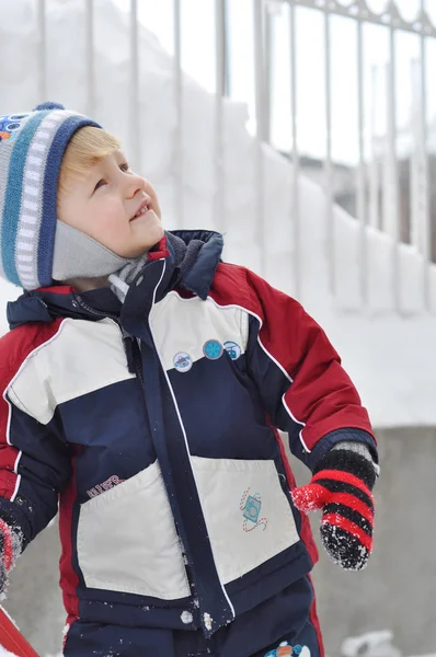 Cheerful boy in snowy landscapes looking up with space for text — Stock Photo, Image