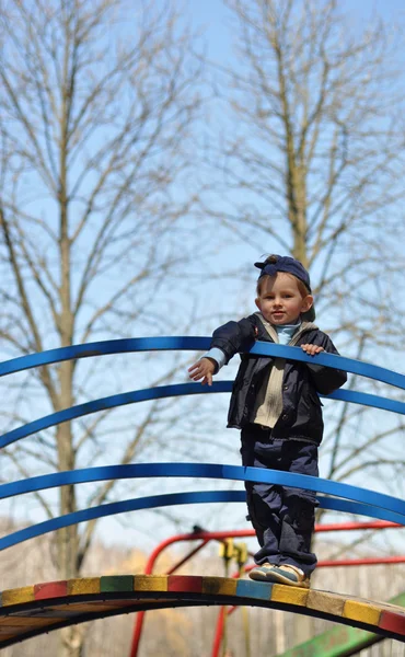 Bébé heureux drôle joue sur le terrain de jeu contre le ciel — Photo