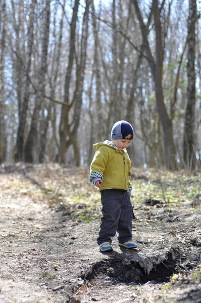 Bambino in piedi sopra il fosso per una passeggiata nel bosco — Foto Stock