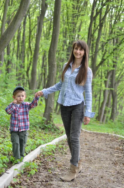 Unga vackra mor och barn på en promenad i parken — Stockfoto