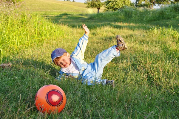 Ребенок играет в футбол на поле — стоковое фото