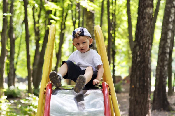 Bayi turun pada slide anak-anak di taman bermain — Stok Foto