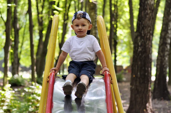 Anak-anak turun di atas anak slide di taman bermain — Stok Foto